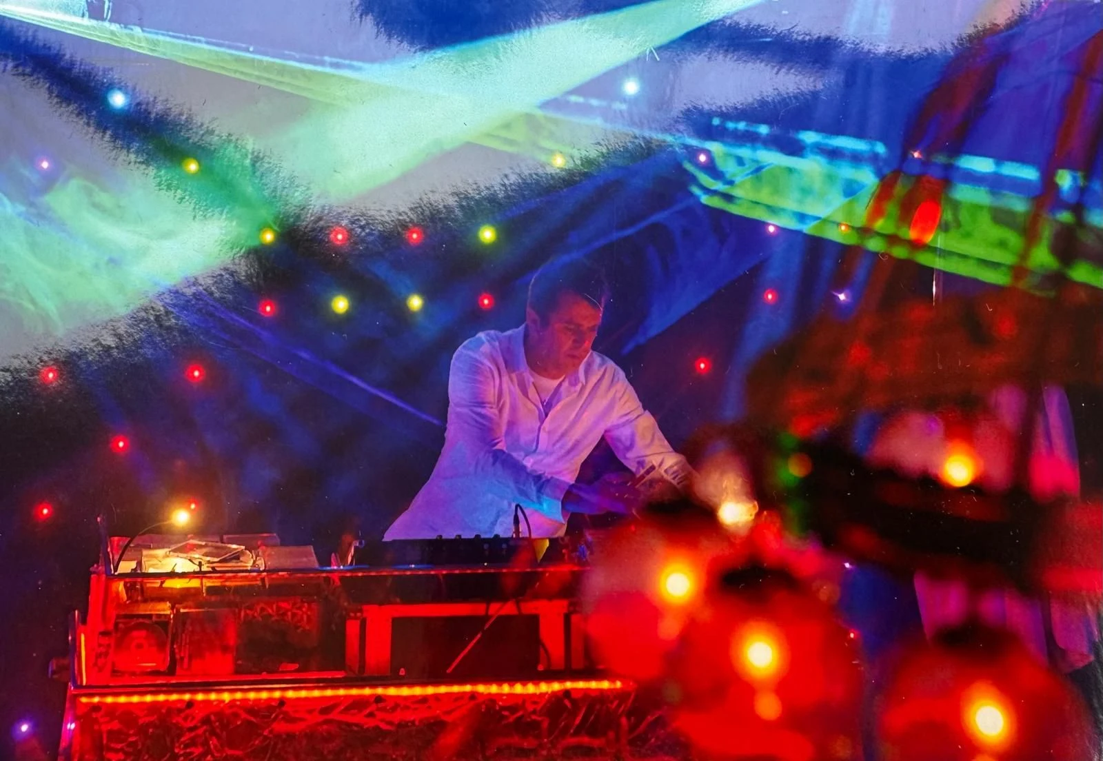 DJ BRUDDAL am Mischpult zwischen farbigen Lichtern und Laserstrahlen