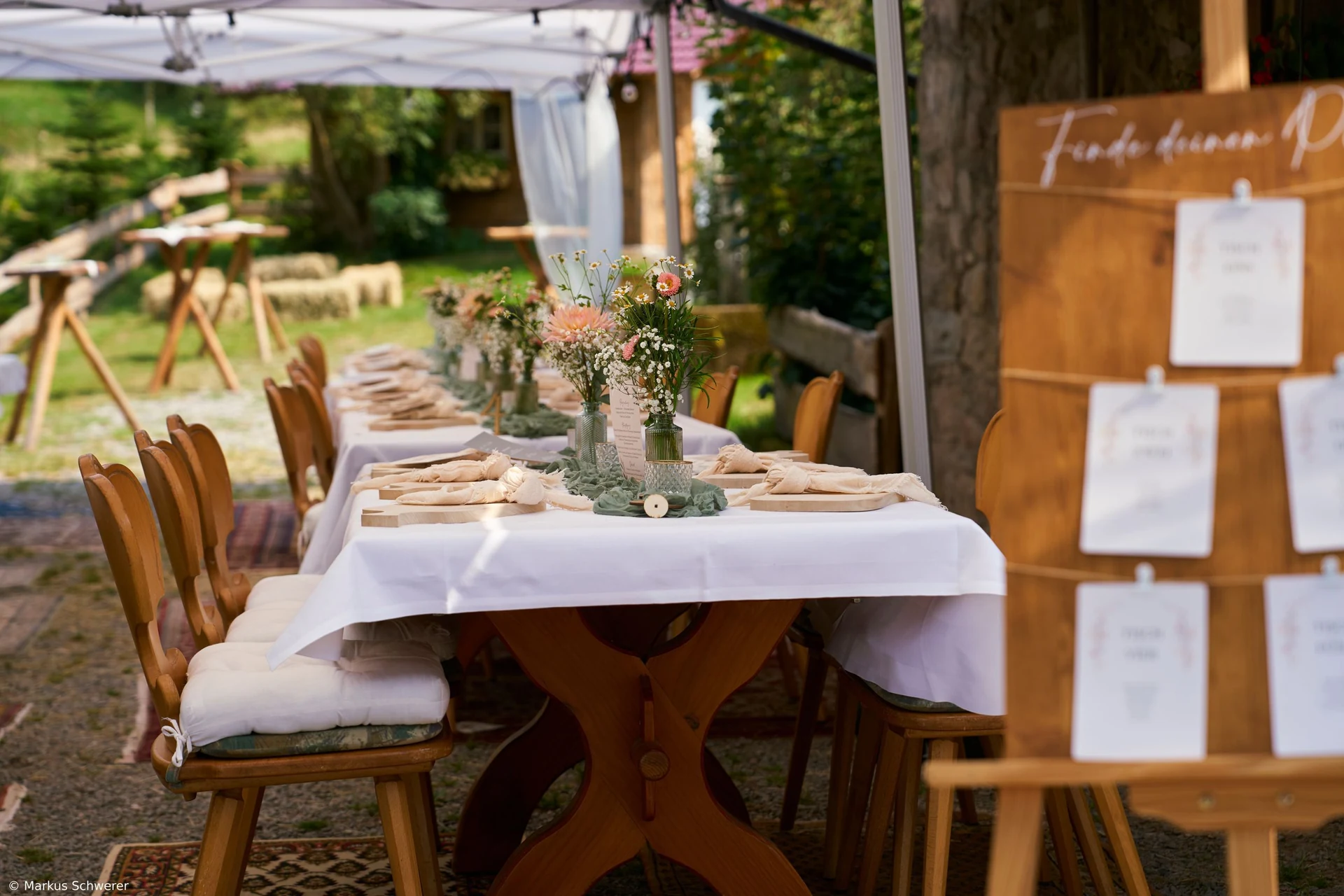 Lange gedeckte Tafel unter einem Pavillon im Außenbereich von Müllers Mühle