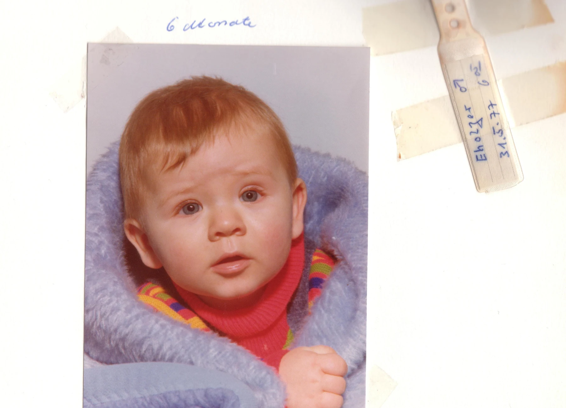 Babyfoto im Originalalbum mit handschriftlicher Beschriftung und erhaltenen Alterungsspuren