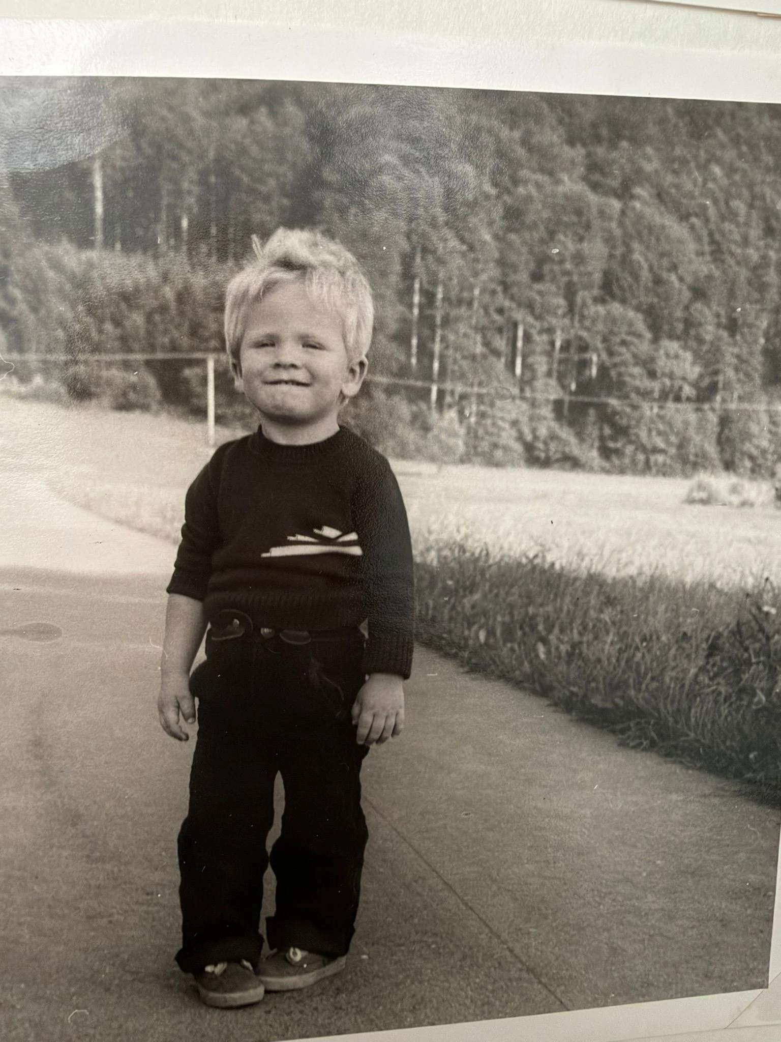 Rainer als kleines Kind draußen vor einem Zaun