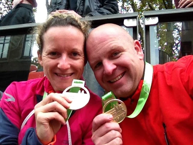 Anja und Rainer zeigen lachend ihre Medaillen nach dem Lauf in Köln 2014