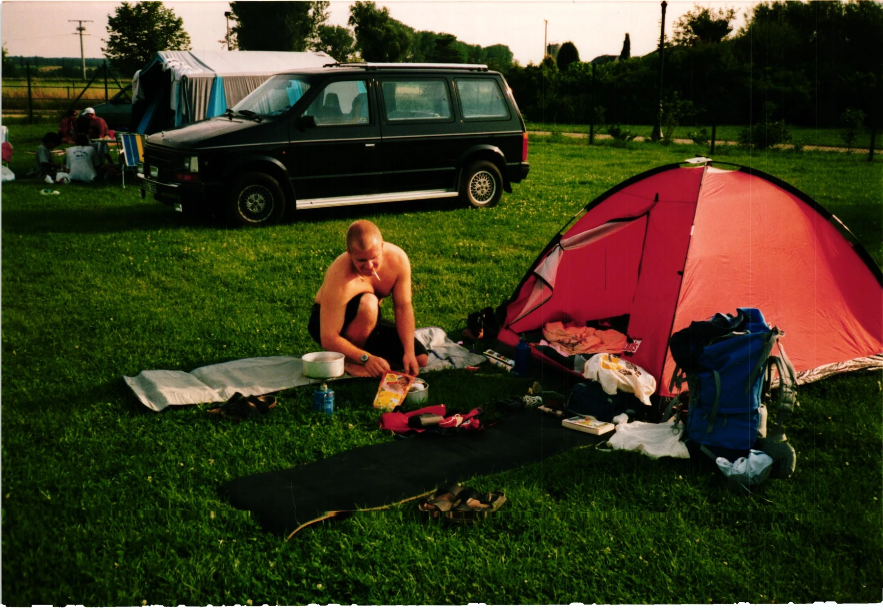 Camping mit kleinem Zelt, Rucksäcken und improvisiertem Lager